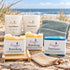 Küstenmoment – Nordsee-Auszeit: drei Naturseifen, Leuchtfeuer und Steuermann mit einzeln wählbarer Glasfarbe, Seifengitter, Leinenbeutel und Gästehandtuch. Beispielkombination.