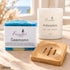 Frische Auszeit – Ankommen: Seemann Naturseife, Ankerplatz Duftkerze mit wählbarer Glasfarbe und kompakte Holzseifenschale. Beispielkombination.