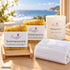 Sanfte Auszeit – Sonneninsel von Friesenzart mit 2 × Naturseife Sommersonne, 1 × Duftkerze Südseetraum, 1 × Gitter hell, 1 × Handtuch Weiß. Beispielkombination; Kerzenglasfarbe frei wählbar.